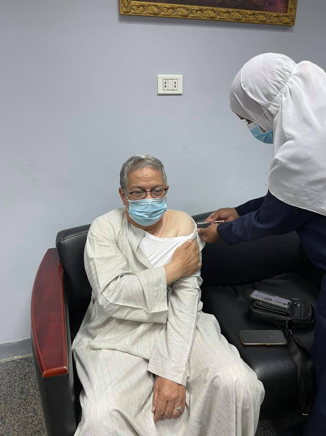 الشيخ محمد الرملى امين عام بيت العائلة خلال تلقى اللقاح