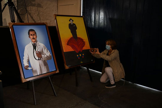 امرأة تلتقط صوراً لرسومات هيرنانديز في كنيسة