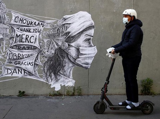 رجل يركب دراجة بخارية كهربائية أمام لوحة جدارية لفنان الشارع أرديف في باريس