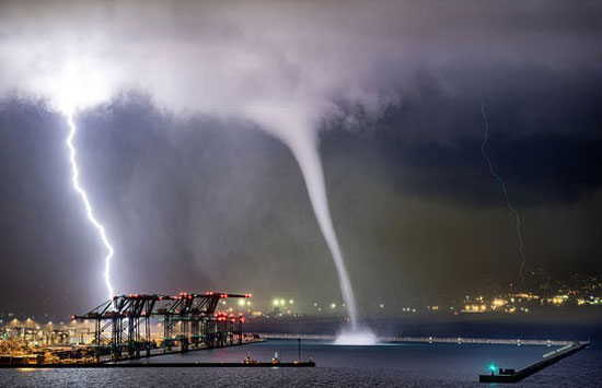 إعصار مائي يتحرك نحو ميناء صناعي مع صواعق من البرق