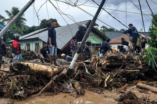 سكان يتفقدون الأنقاض بالقرب من المنازل المتضررة في قرية وايورانج