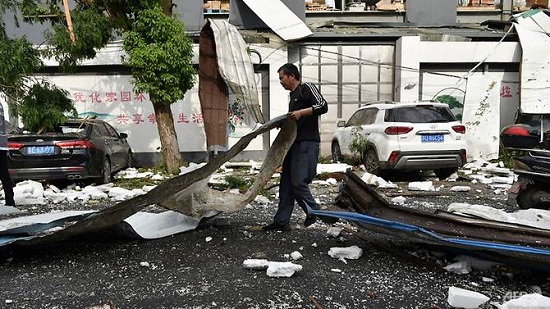 رجل ينظف الأضرار بعد إعصار ضرب مدينة سوتشو