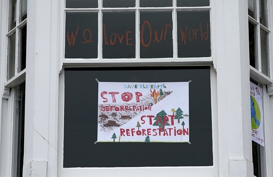 لافتة حول إزالة الغابات في نافذة منزل في سانت آيفز