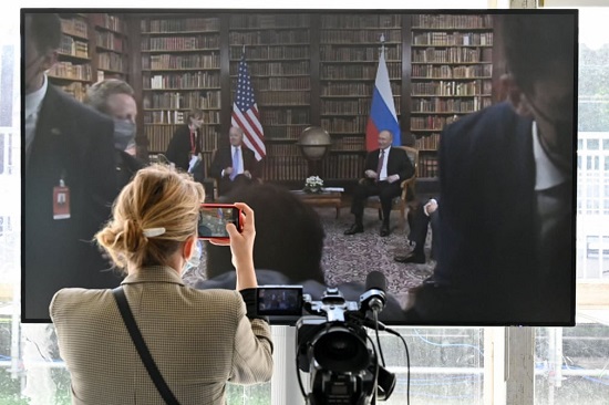 صحفي يلتقط صورة للشاشة المعروضة في غرفة الصحافة