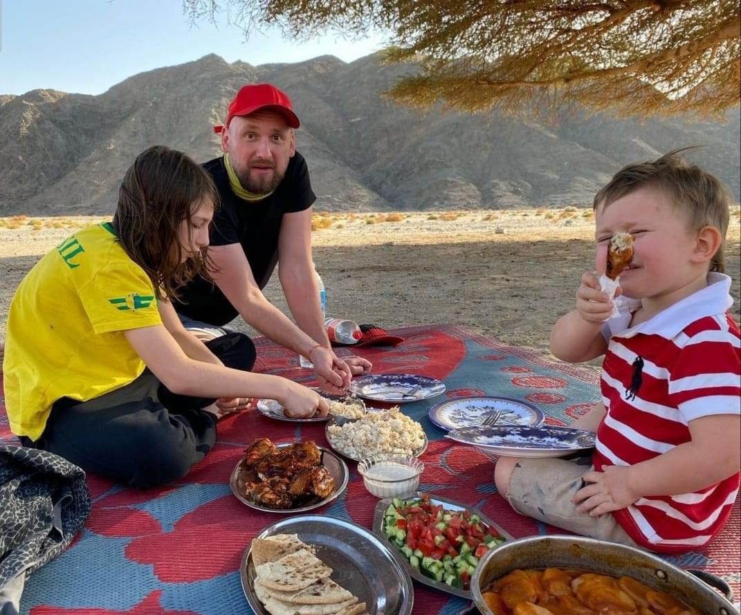 اسرة اجنبية تتناول الغداء بالصحراء