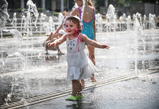 يتجول الأطفال في نوافير العاصمة حيث بلغت درجات الحرارة 34.7 درجة مئوية