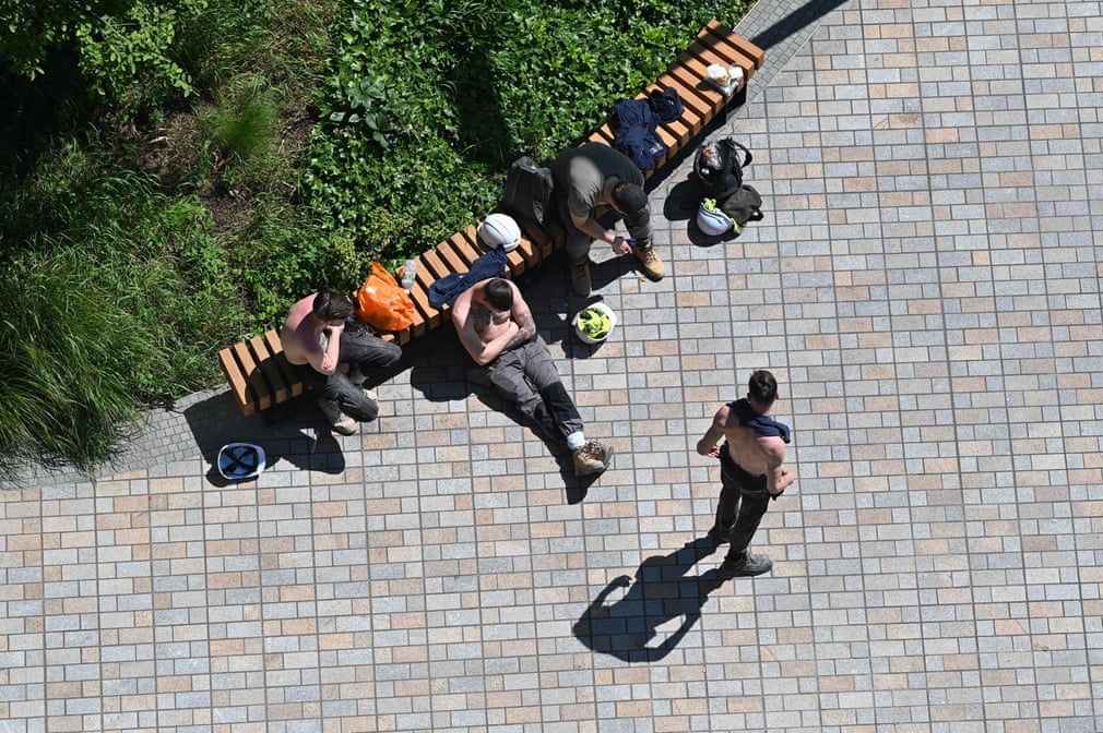 عمال البناء في لندن يسترخون في الشمس خلال فترة الراحة