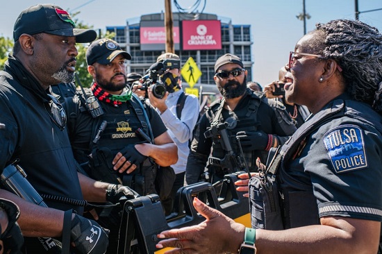 يحاول ضابط شرطة نزع فتيل مواجهة بين أعضاء حزب النمر الأسود ومتظاهرين