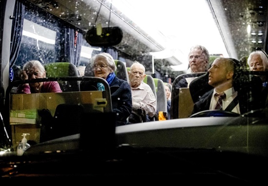 السكان الذين تم إجلاؤهم من دار رعاية يجلسون داخل حافلة أثناء نقلهم