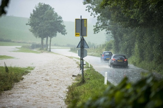السيارات تسير بالقرب من الحقول التي غمرتها الفيضانات في أوباخسبرغ بهولندا
