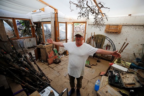 رجل يقف داخل منزل مدمر بعد هطول أمطار غزيرة