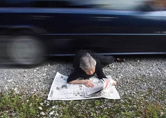 تقرأ الجريدة تحت سيارة
