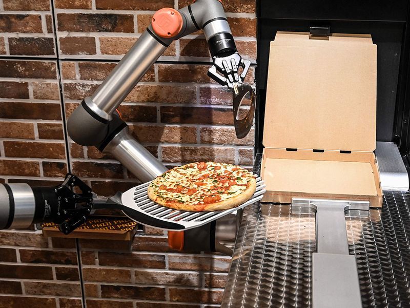 الروبوت يقوم بعملية تغليف البيتزا