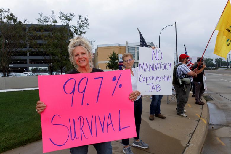 مواطنة أمريكية تحمل لافتة ضد انتشار فيروس كورونا