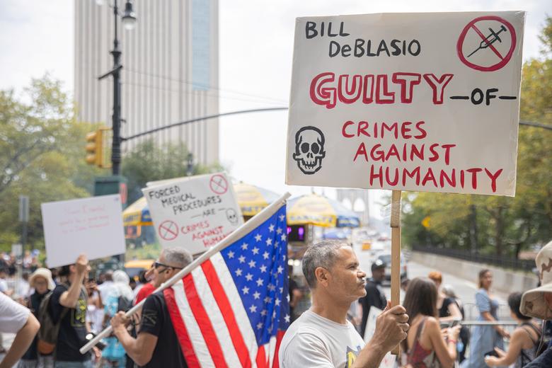 رجل يحمل لافتة أثناء احتجاج ضد لقاح فيروس كورونا الإلزامي خارج نيويورك سيتي
