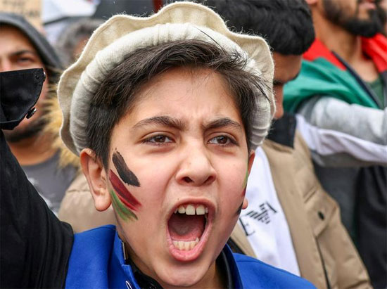 متظاهر رسم على وجهه بألوان علم أفغانستان يصرخ خلال مظاهرة تضامنية مع شعب أفغانستان فى لندن