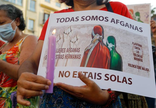 امرأة تحمل شمعة ولافتة كتب عليها كل النساء أفغانيات ، ولست وحدك فى إسبانيا .