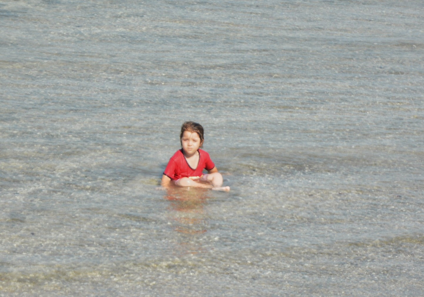 طفلة تلعب في مياه البحر