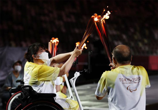 يتم نقل شعلة أولمبياد المعاقين إلى شعلة خلال حفل الافتتاح.