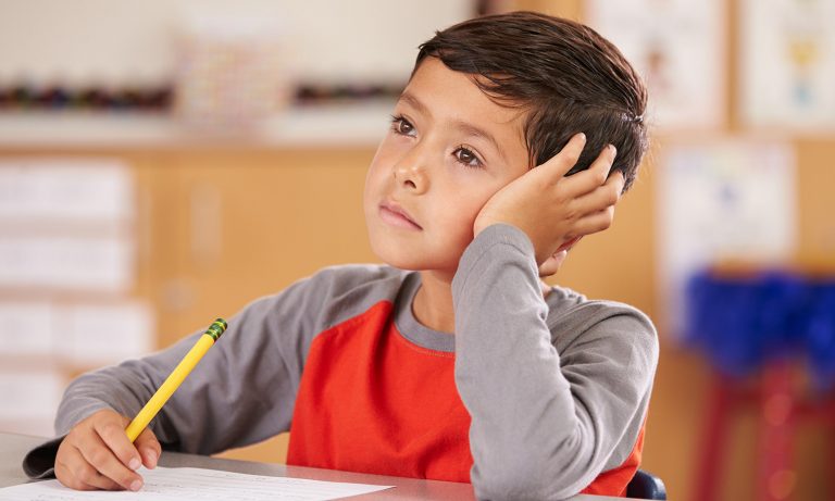 young-boy-at-school-desk-staring-into-space-768