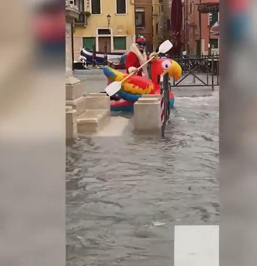 رجل بزى سانتا كلوز يطفو على مياه الفيضان