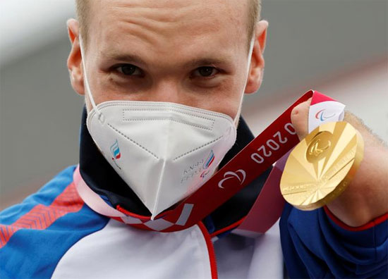 يحتفل الحاصل على الميدالية الذهبية ميخائيل أستاشوف من اللجنة البارالمبية الروسية على منصة التتويج في سباق الدراجات التجريبية للرجال