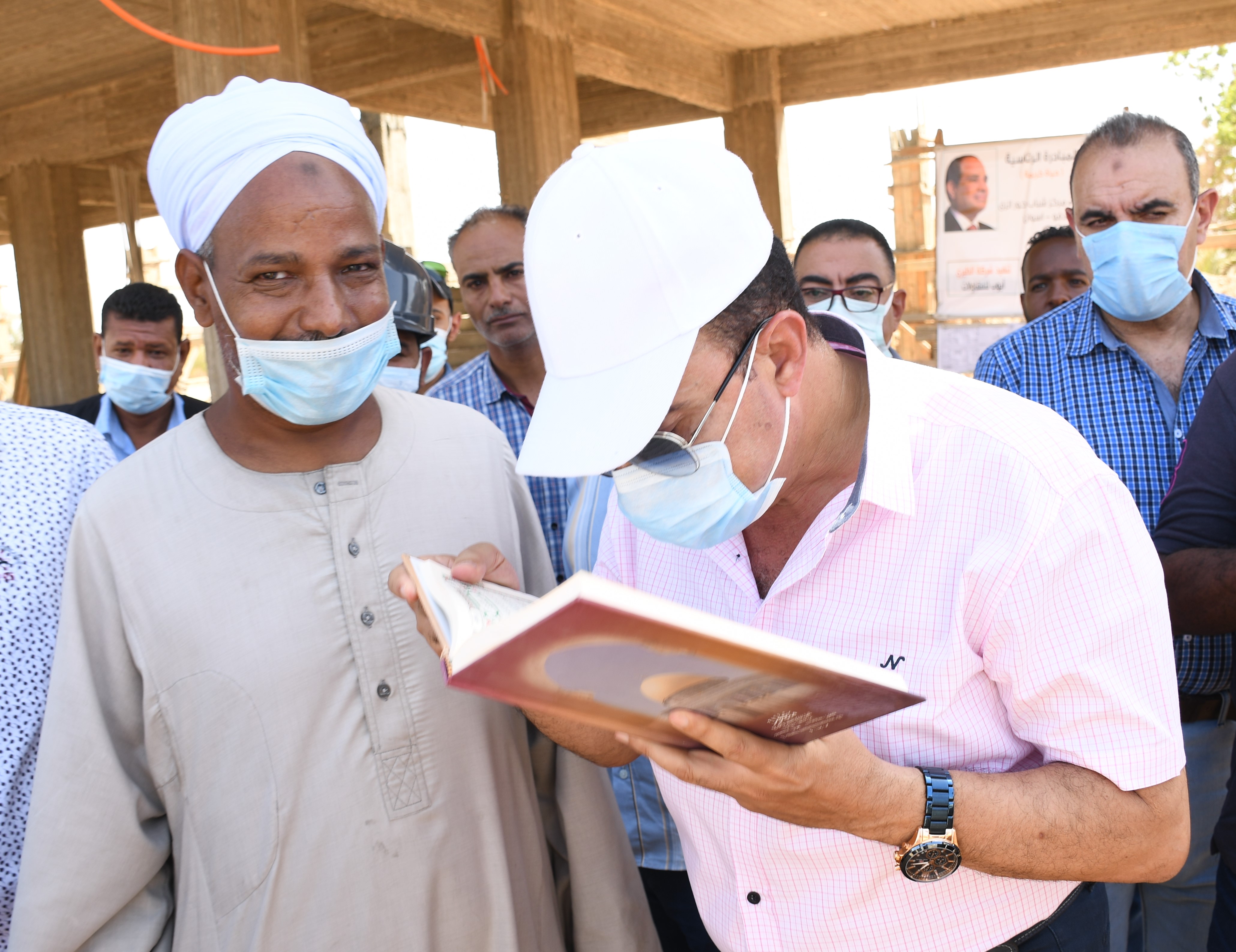 محافظ أسوان يقبل كتاب الله الذى اعطاه له احدى مواطنى قرية العطوانى (1)