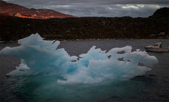 جبل جليدي يمر أثناء غروب الشمس في نوك