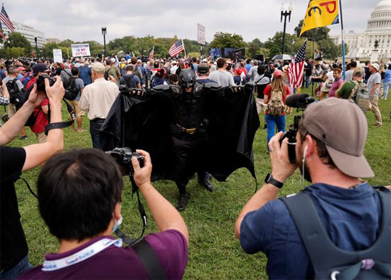 شخص يرتدي زي باتمان يقف لالتقاط صور خلال مسيرة لدعم المتهمين الذين تتم مقاضاتهم في هجوم 6 يناير على مبنى الكابيتول الأمريكي