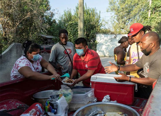 المهاجرون الذين يطلبون اللجوء في الولايات المتحدة يشتروا الطعام من بائع متجول