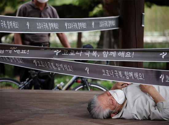 رجل يستريح في جناح تم تطويقه كإجراء لتجنب انتشار فيروس كورونا في حديقة في سيول ، كوريا الجنوبية