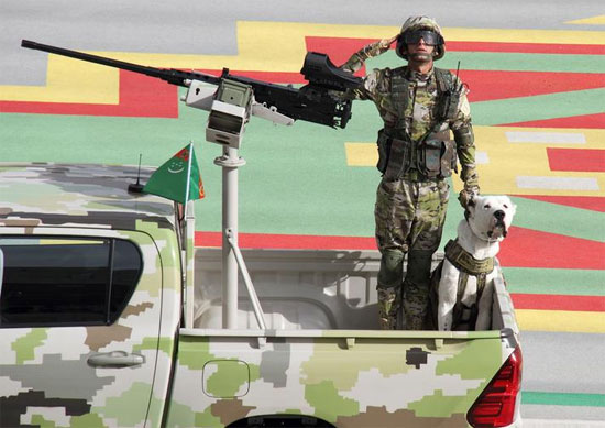 جندي  يركب مع كلب في شاحنة صغيرة خلال عرض عسكري بمناسبة عيد استقلال تركمانستان