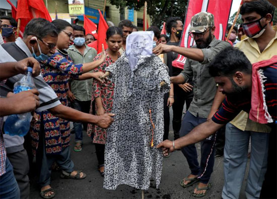 نشطاء من الحزب الشيوعي الهندي (الماركسي اللينيني) أو CPI-ML يحرقون دمية تصور رئيس الوزراء الهندي ناريندرا مودي في احتجاج خلال إضراب وطني ضد قوانين المزارع ، في كولكاتا ، الهند