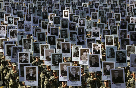 جنود يحملون صورًا لأفراد الخدمة الآذريين الذين قُتلوا في النزاع الأخير على منطقة ناغورنو كاراباخ خلال الاحتفال بالذكرى السنوية الأولى ، في باكو ، أذربيجان