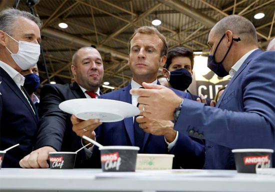 الرئيس الفرنسي إيمانويل ماكرون وممثله الشخصي لفن الطهو Guillaume Gomez تذوق السلع خلال زيارة للمعرض الدولي للتموين والفنادق والأغذية (SIRHA) في قاعة Eurexpo في ليون ، فرنسا