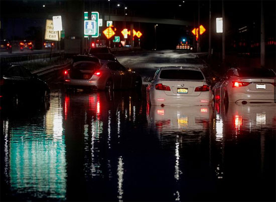 سيارات مهجورة تركت على طريق سريع غمرته المياه في حي كوينز بمدينة نيويورك.