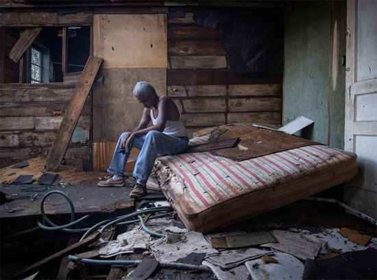ثيوفيلوس تشارلز ، 70 عامًا ، يجلس داخل منزله الذي تضرر بشدة من إعصار إيدا