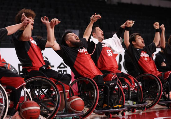 لاعبو اليابان على مقاعد البدلاء يتفاعلون خلال مباراة كرة السلة على الكراسي المتحركة في نصف النهائي ضد بريطانيا