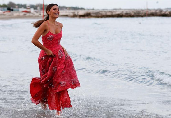 سيرينا روسي تقف خلال جلسة تصوير على الشاطئ.