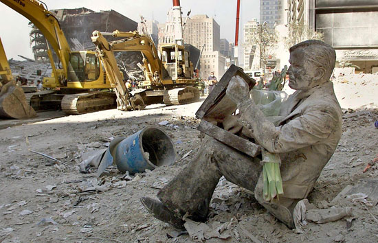 تمثال برونزي مغطى بالغبار لرجل مع حقيبته يرقد تحت أنقاض مركز التجارة العالمي