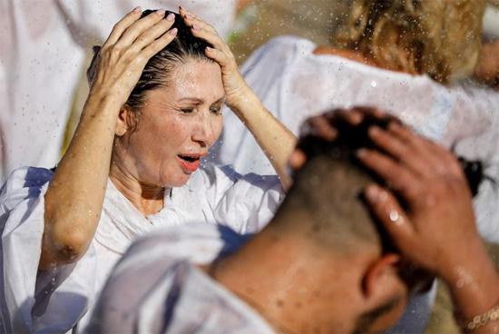 مصلون يشاركون في مراسم التعميد في نهر الأردن للاحتفال بعيد الغطاس