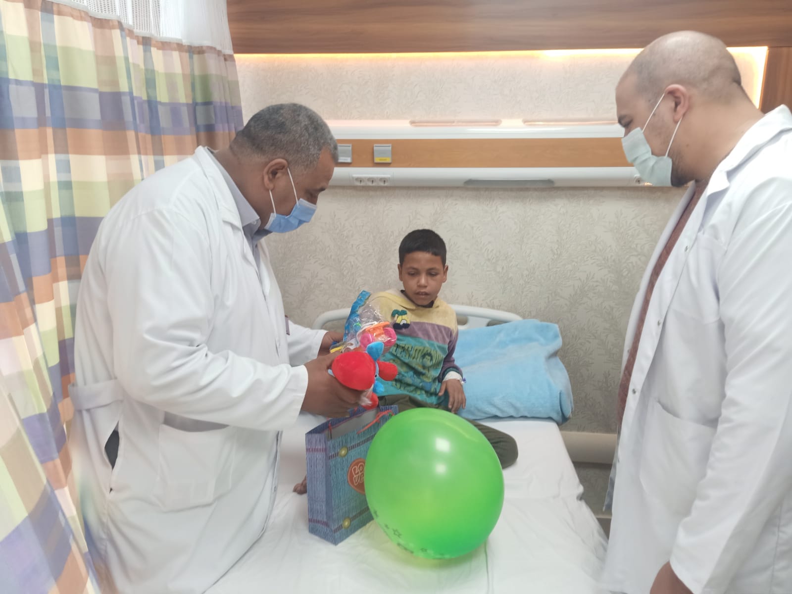 الدكتور خلف خلال توزيع الهدايا على الأطفال