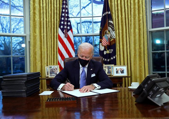 الرئيس جو بايدن يوقع الأوامر التنفيذية في المكتب البيضاوي للبيت الأبيض