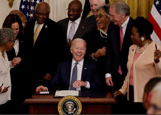 الرئيس جو بايدن يضحك مع نائب الرئيس كامالا هاريس وأعضاء الكونغرس