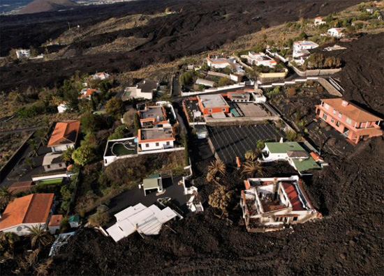 منظر جوي لمجموعة منازل محاطة بحمم بركان كومبري فيجا في منطقة محظورة في لاس مانشاس