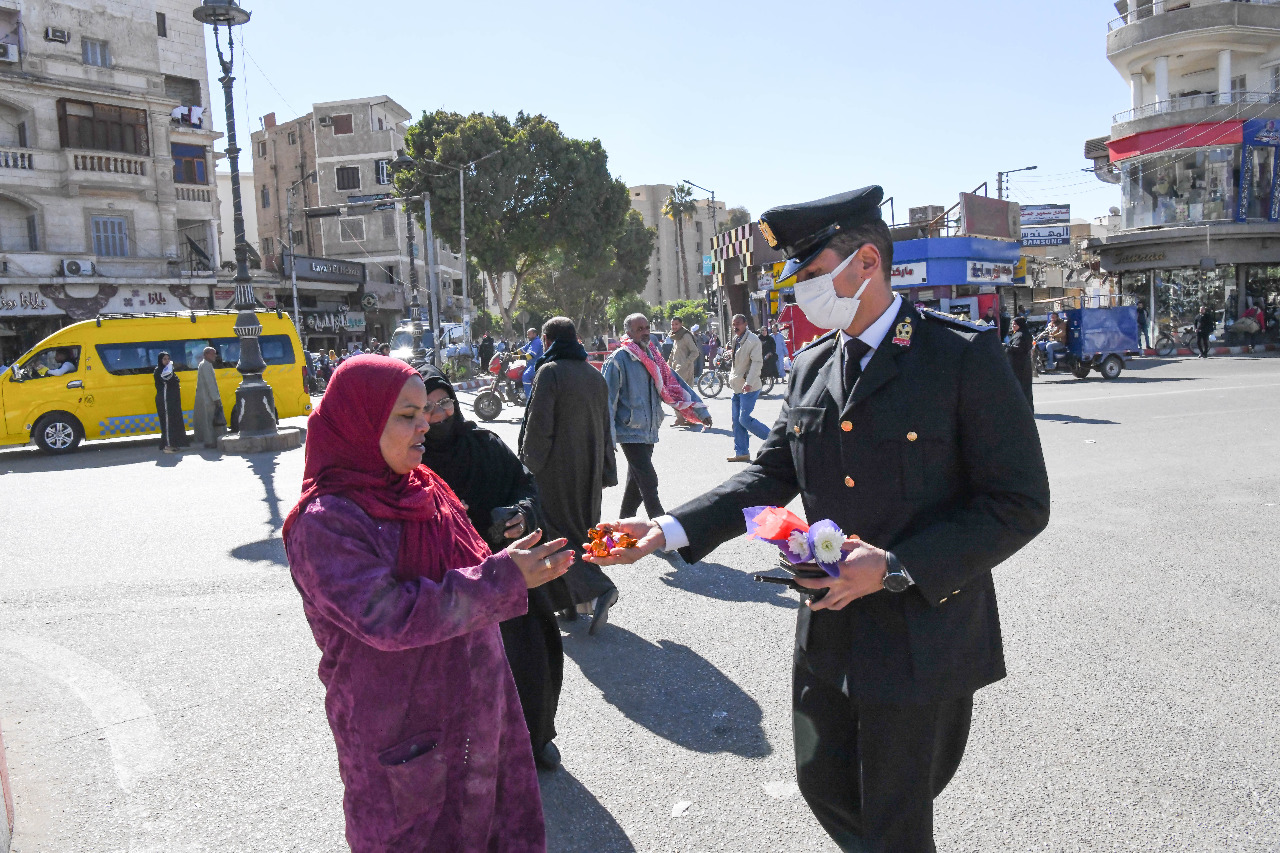 ضباط مرور قنا يوزعون الورود على سائقى السيارات والمواطنين في عيد الشرطة