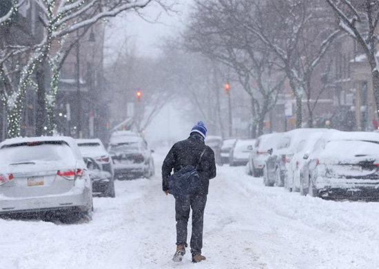 شخص يسير في شارع مغطى بالثلوج