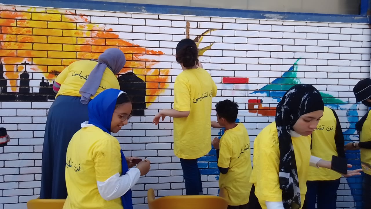 طلاب الإسماعيلية يرسمون أعمال عن قمة المناخ على الأسوار