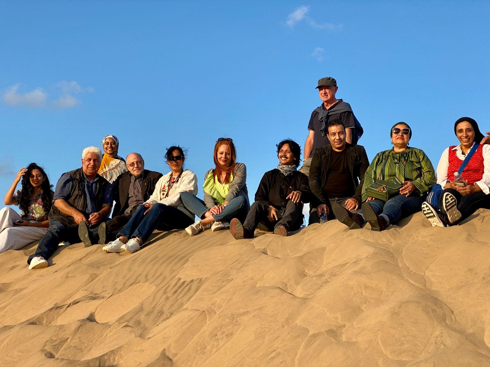 الفانون المشاركون في الملتقى سعداء  بمناظر الرمال وقت الغروب