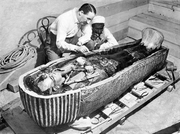 هوارد كارتر وعامل مصري يفحصان التابوت الثالث لتوت عنخ آمون المصنوع من الذهب الخالص